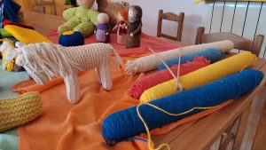 Madeja de lanas diferentes colores y varios muñecos de fieltro y lana