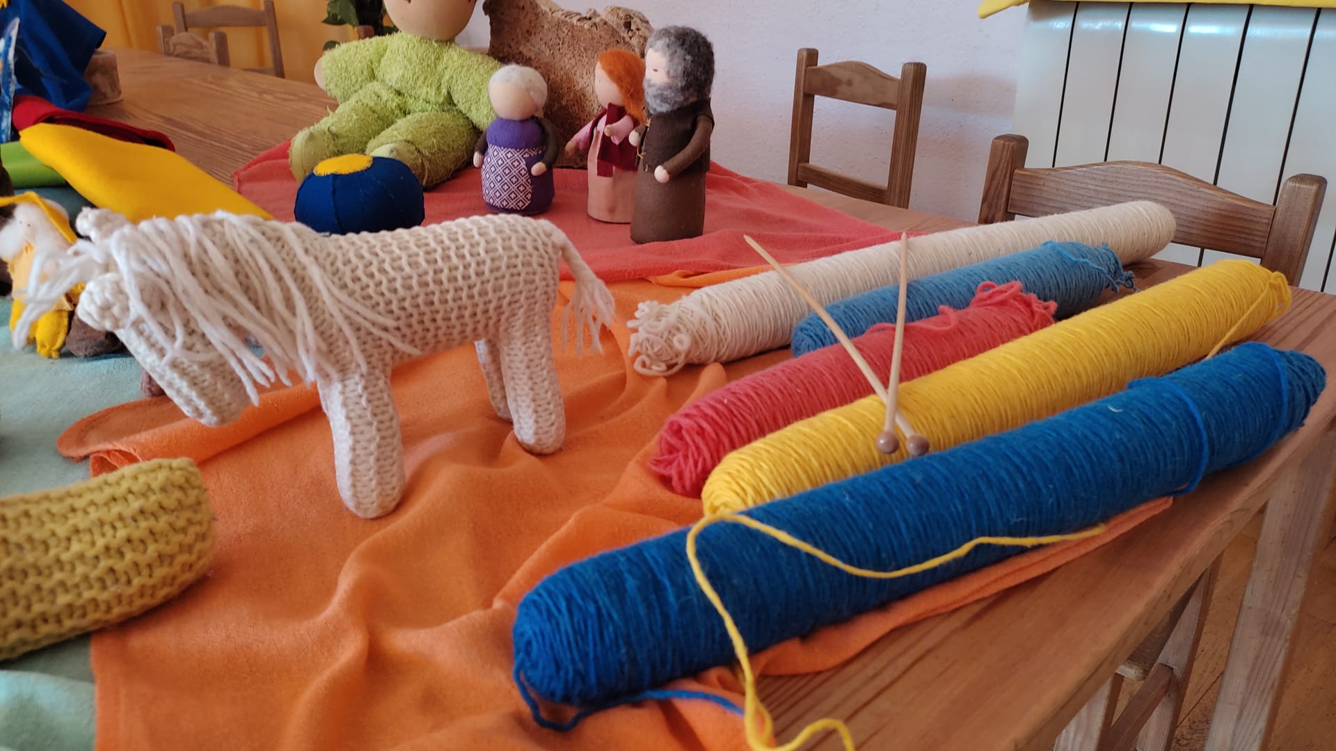 Madeja de lanas diferentes colores y varios muñecos de fieltro y lana
