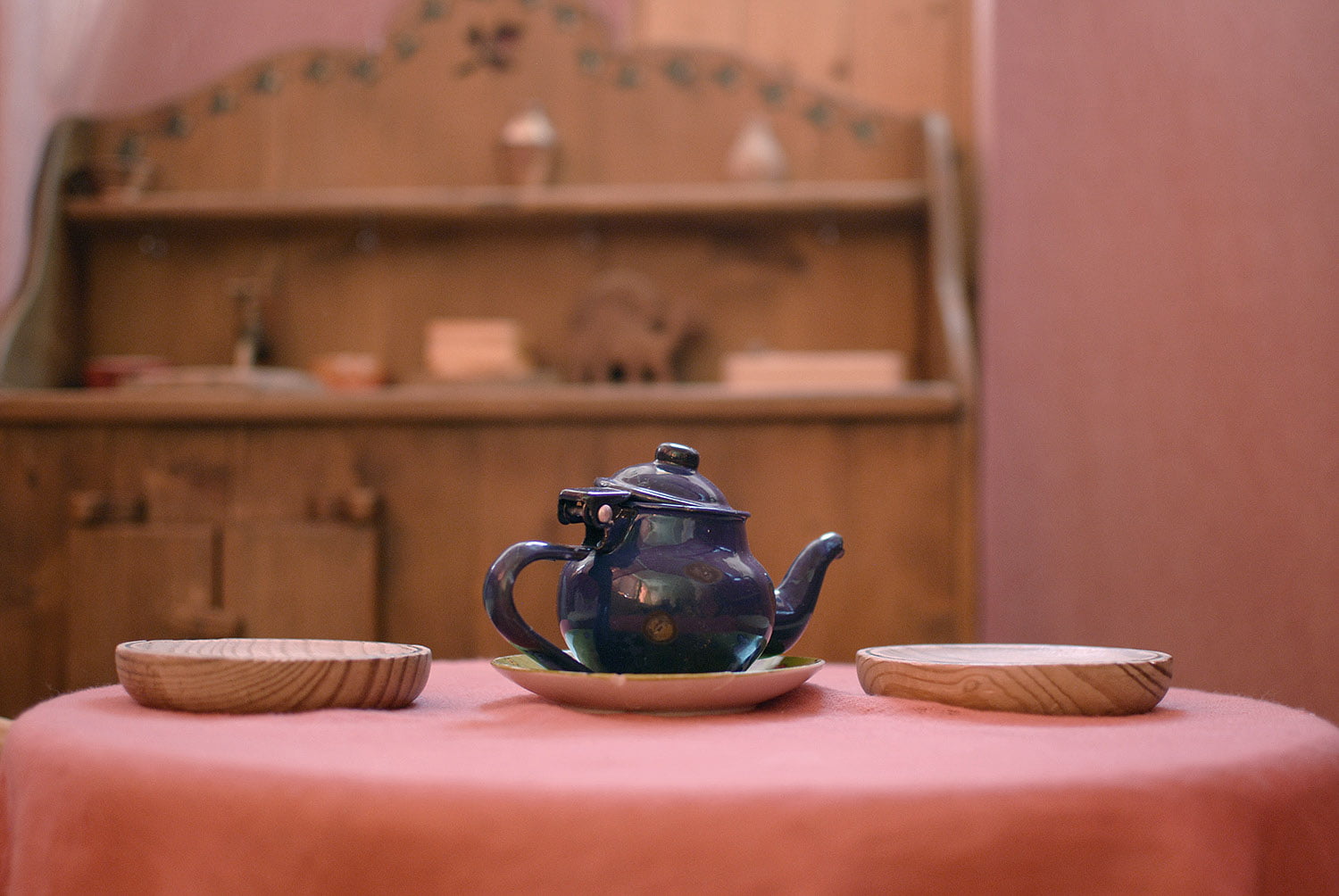 Interior de la casita de juegos del aula de niños de 3 a 6 años en la escuela infantil grimm, primer plano de la mesita con una preciosa tetera azul brillante