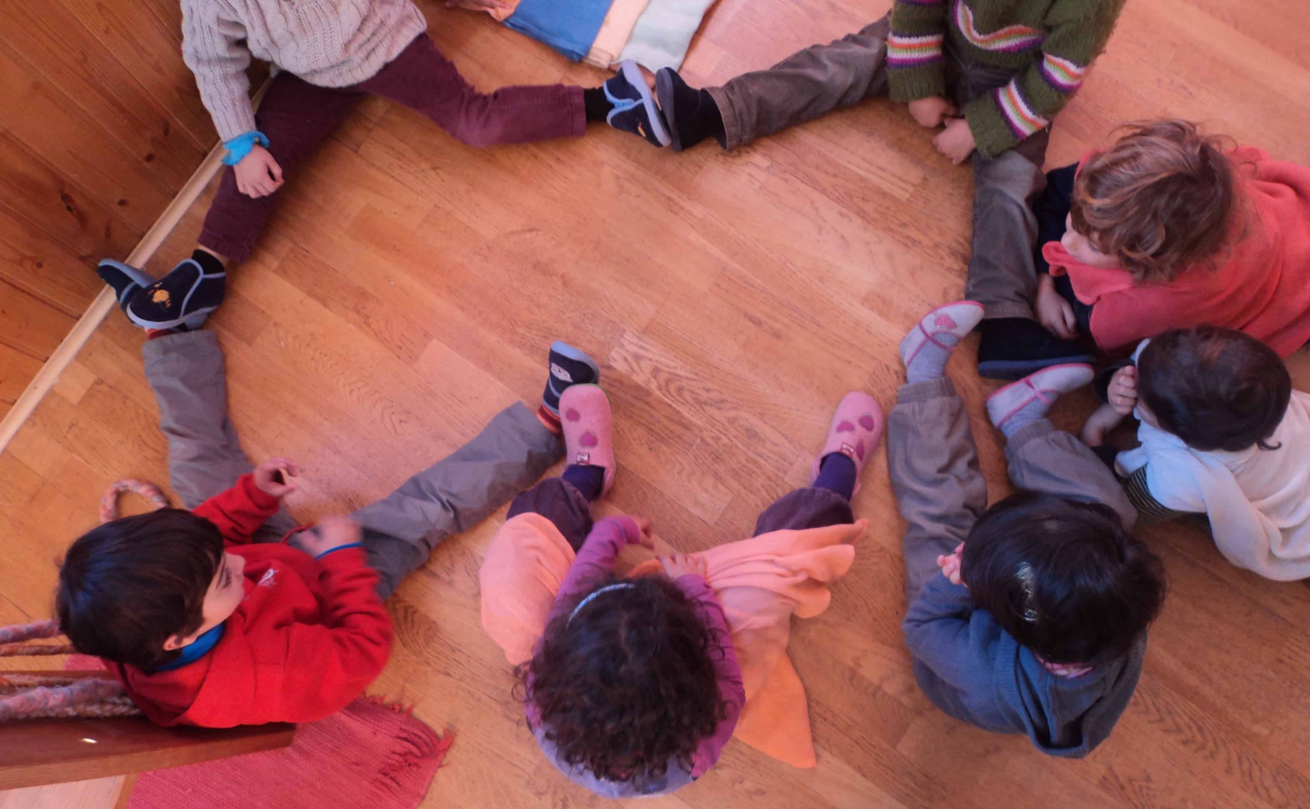Niños jugando a hacer una estrella con las piernas y pies