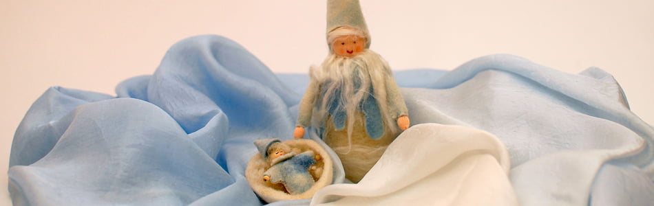La llegada del invierno representada con muñecos realizados en fieltro de lana en un ambiente gelido hecho con seda celeste y blanca