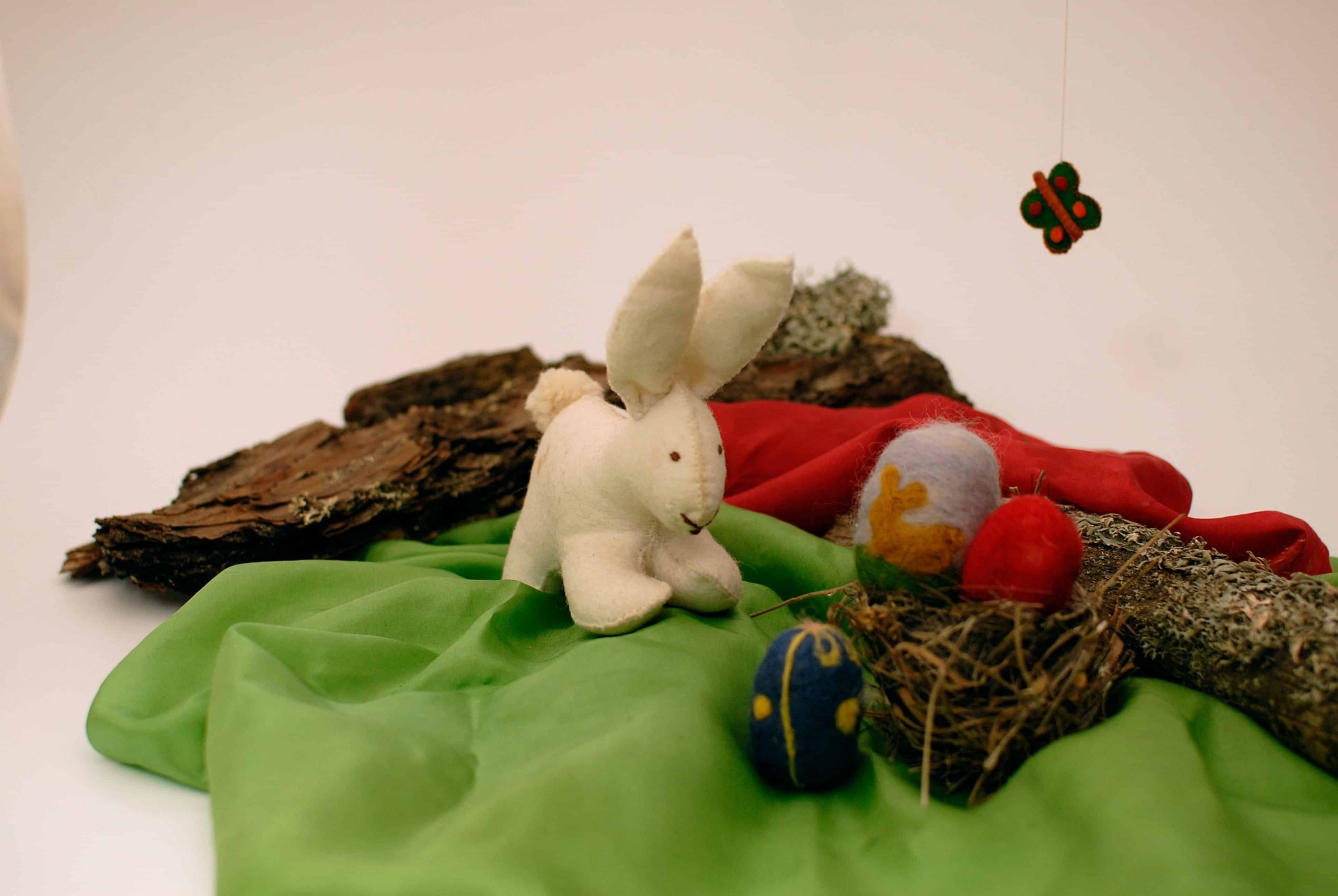 Liebrecita de pascua poniendo los huevos de colores en una cestita hecha con fieltro de lana