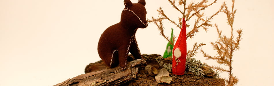 Un oso y seres de la naturaleza sobre un ambiente otoñal que representa la llega del otono realizados en fieltro de lana