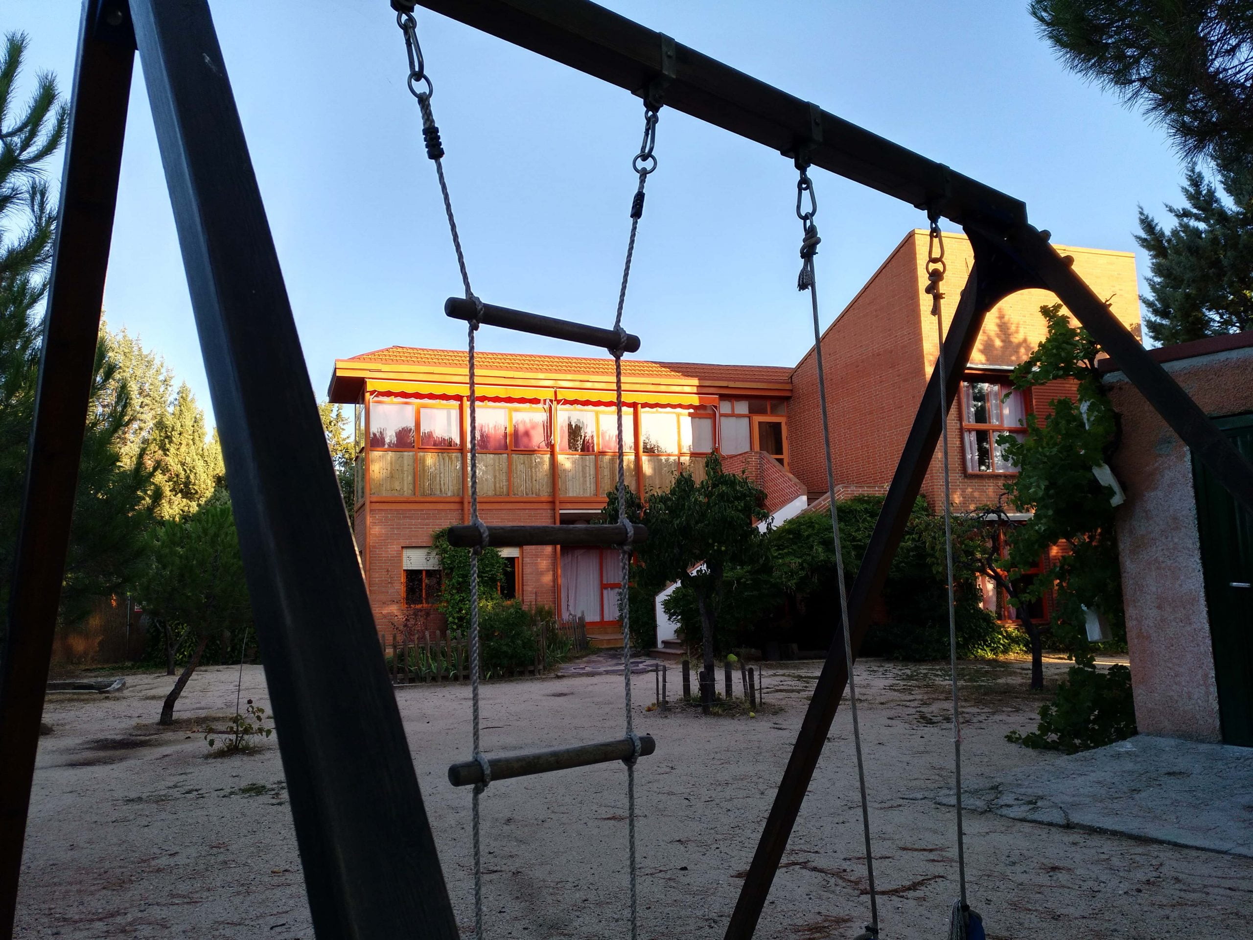 Vista exterior de la escuela waldorf Grimm desde detras del columpio del patio de juegos