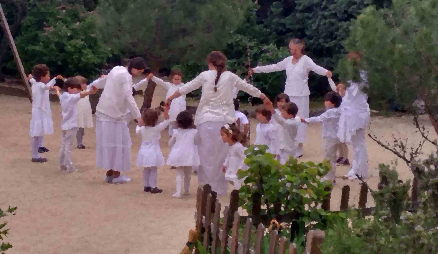 Corro de la palomita en el jardin de la escuela infantil grimm con alumnos y maestras vestidos todos de blanco
